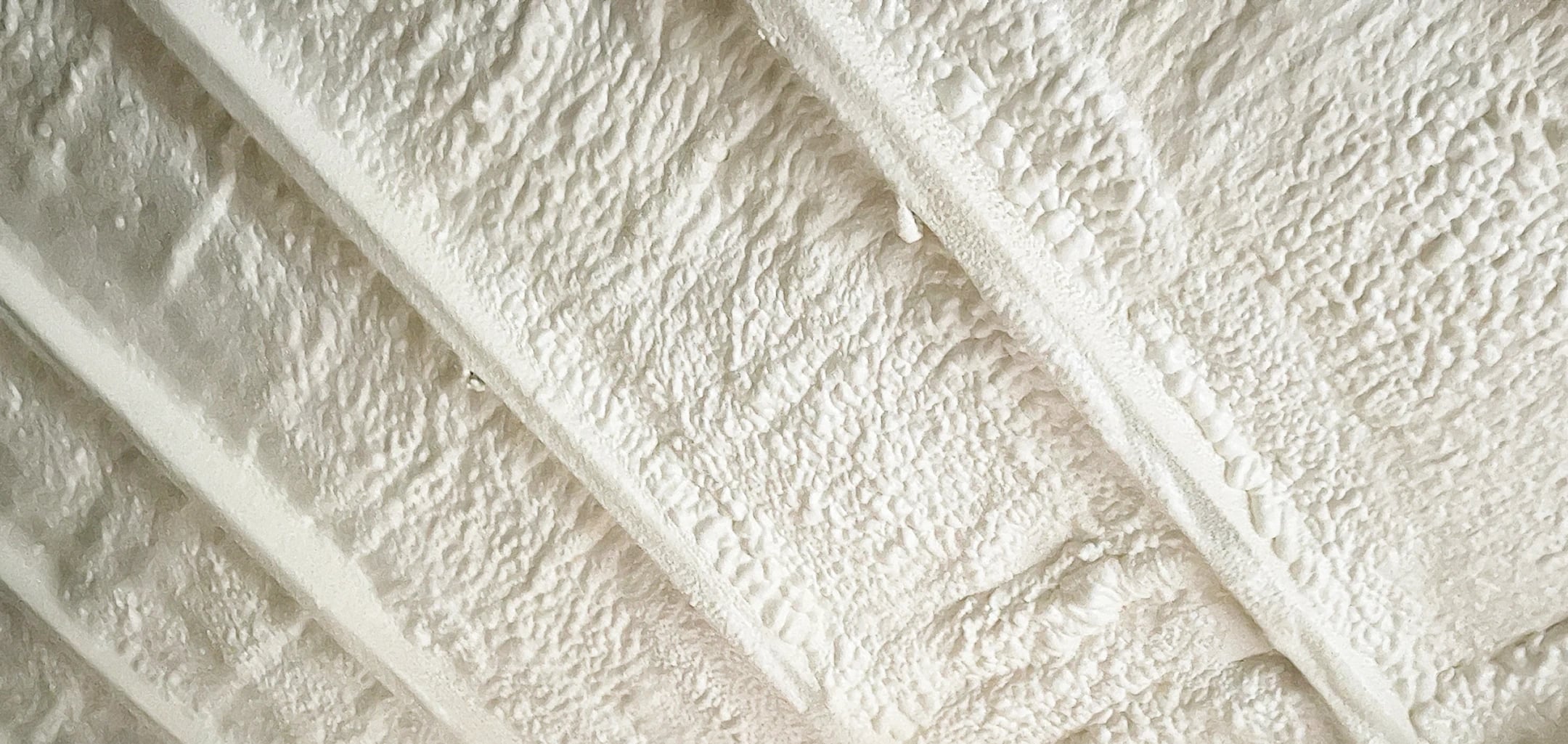 Spray foam covering a roof deck and its framing