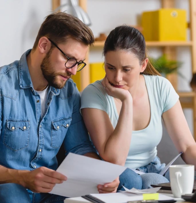 Homeowners reviewing rising energy costs at a kitchen table